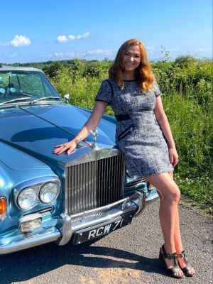 Irita Marriott sit on bher blue car at outdoor