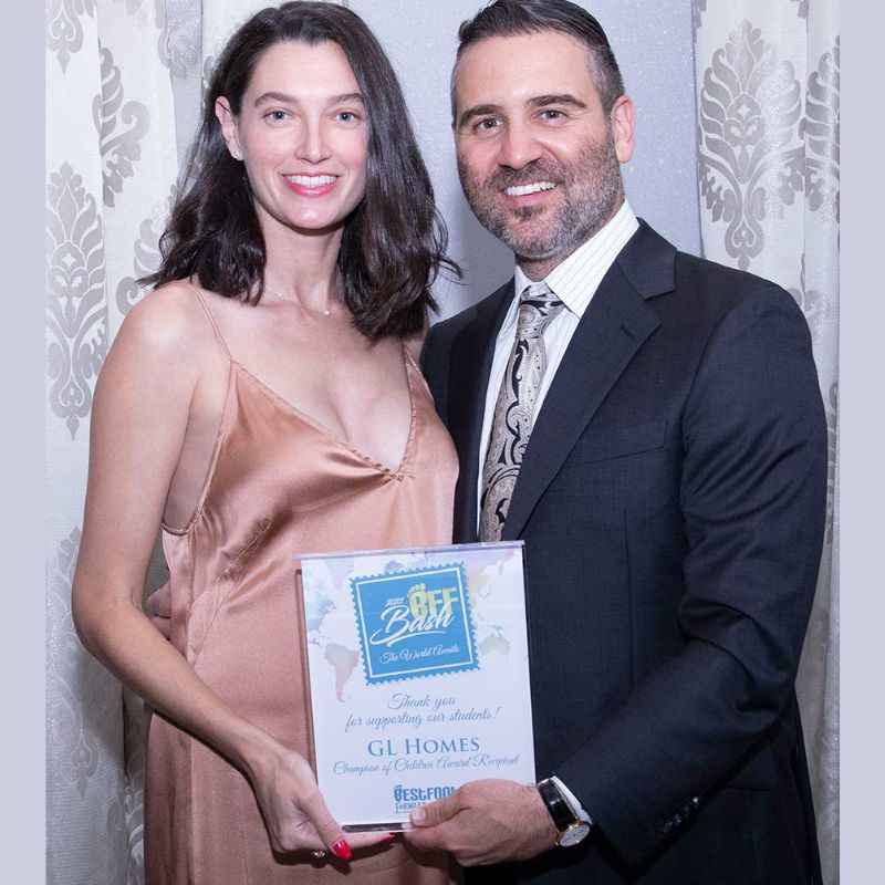 Itzhak Ezratti Is Smiling and holding Best Foot Forward Honors GL Homes With His Wife Jessica Misha Ezratti